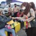 Scout volunteers distributing face masks to a children-toys seller in a bus terminal.